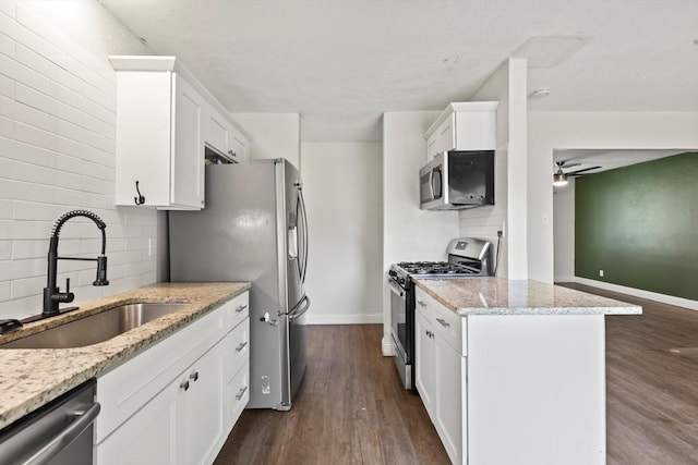 5509 Cloverdale Dr, Fort Worth, TX 76134 - kitchen featuring appliances with stainless steel finishes, a sink, white cabinetry, backsplash, and baseboards