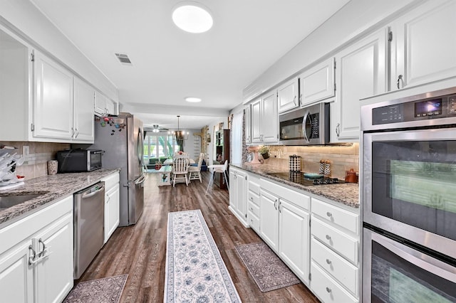 1705 W Belden St, Sherman, TX 75092 - kitchen featuring stainless steel appliances, white cabinetry, dark wood-style flooring, tasteful backsplash, and light stone countertops