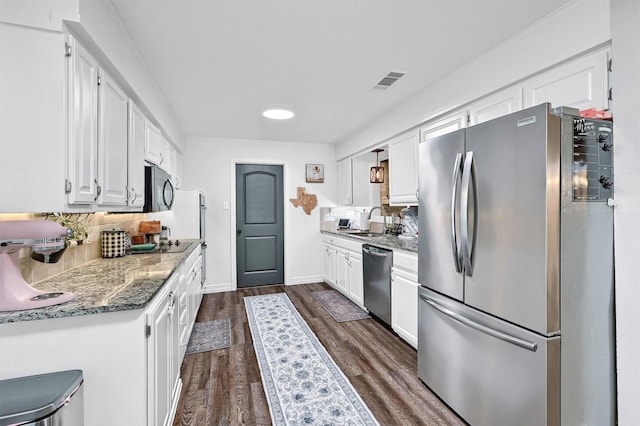 1705 W Belden St, Sherman, TX 75092 - kitchen featuring appliances with stainless steel finishes, white cabinetry, tasteful backsplash, dark wood-type flooring, and a sink