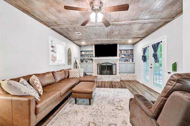1705 W Belden St, Sherman, TX 75092 - living room with wood finished floors, wooden ceiling with exposed beams, a ceiling fan, a fireplace with raised hearth, and built in features