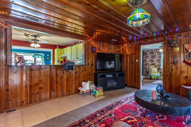 216 E Tennie St, Gainesville, TX 76240 - carpeted living room featuring wood walls and ceiling fan