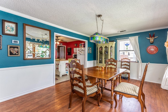 216 E Tennie St, Gainesville, TX 76240 - dining area featuring a textured ceiling, ornamental molding, wood finished floors, and ceiling fan