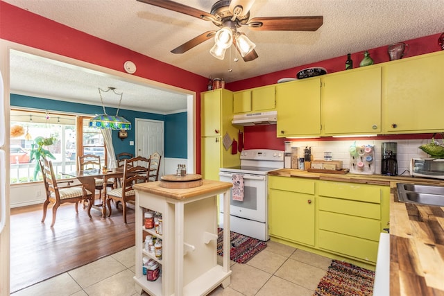 216 E Tennie St, Gainesville, TX 76240 - kitchen featuring electric range, under cabinet range hood, a textured ceiling, butcher block counters, and light tile patterned floors