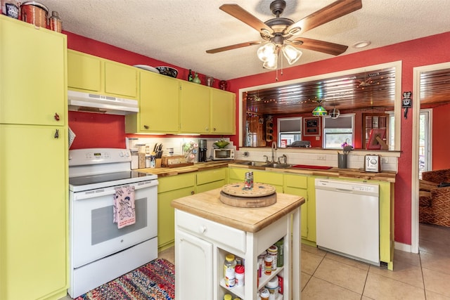 216 E Tennie St, Gainesville, TX 76240 - kitchen featuring white appliances, under cabinet range hood, a sink, wood counters, and a textured ceiling