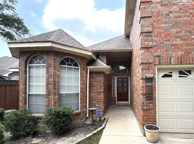 600 Black Rock Ct, Irving, TX 75063 - property entrance featuring brick siding, roof with shingles, and a garage