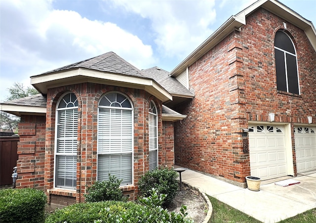 600 Black Rock Ct, Irving, TX 75063 - view of property exterior with brick siding, a shingled roof, a garage, and driveway