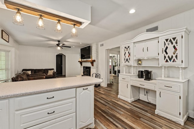 519 S Pearl St, Kemp, TX 75143 - kitchen featuring a ceiling fan, a fireplace, dark wood-style flooring, white cabinets, and light countertops