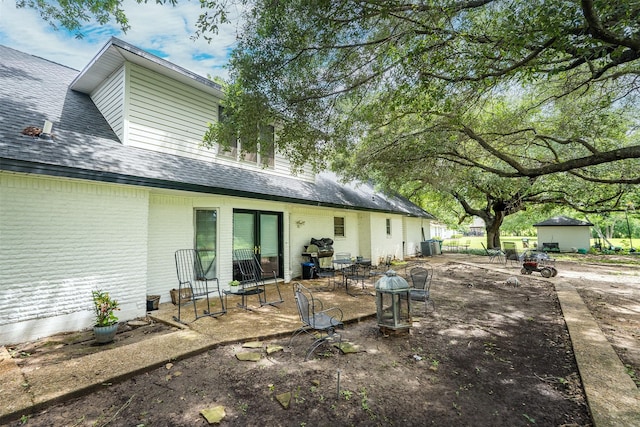 519 S Pearl St, Kemp, TX 75143 - rear view of house featuring brick siding, roof with shingles, and central air condition unit