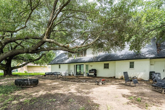519 S Pearl St, Kemp, TX 75143 - rear view of house featuring a fire pit, brick siding, and roof with shingles