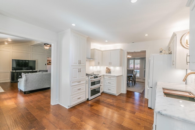 1233 Stegall Rd, Keller, TX 76248 - kitchen featuring range with two ovens, a sink, white cabinetry, dark wood-type flooring, and light stone countertops