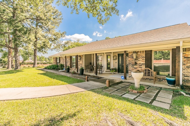 1233 Stegall Rd, Keller, TX 76248 - back of house with covered porch, a lawn, brick siding, and a shingled roof