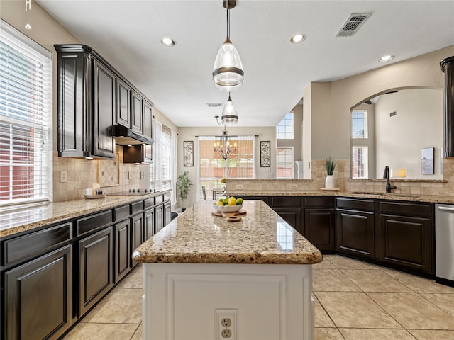 1308 Crown Point Rd, Mckinney, TX 75072 - kitchen featuring a kitchen island, a sink, decorative backsplash, light tile patterned flooring, and light stone counters