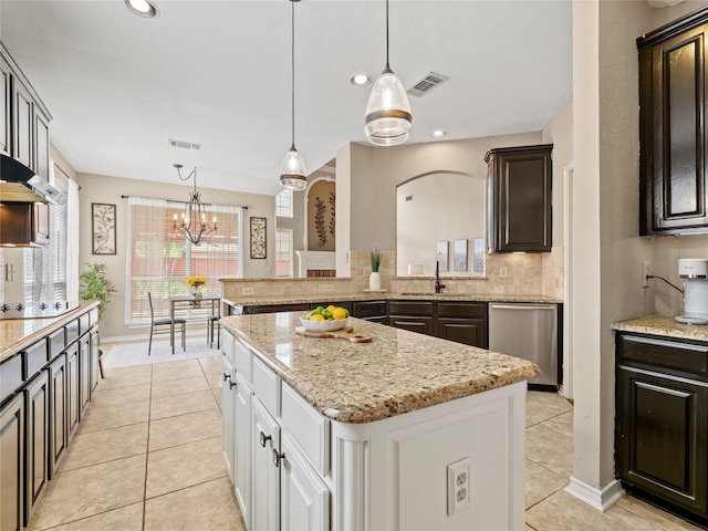 1308 Crown Point Rd, Mckinney, TX 75072 - kitchen featuring stainless steel dishwasher, a sink, light tile patterned floors, backsplash, and light stone counters