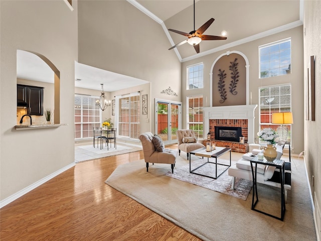 1308 Crown Point Rd, Mckinney, TX 75072 - living room featuring crown molding, high vaulted ceiling, light wood-style flooring, a fireplace, and baseboards