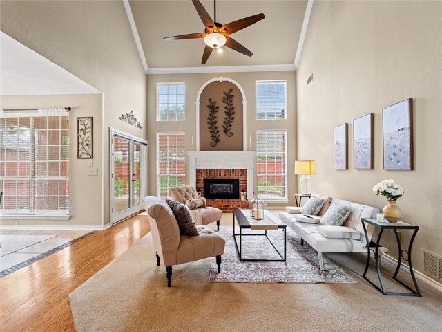 1308 Crown Point Rd, Mckinney, TX 75072 - living room featuring ornamental molding, baseboards, a towering ceiling, a ceiling fan, and a brick fireplace