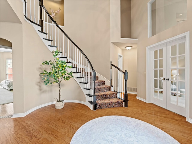 1308 Crown Point Rd, Mckinney, TX 75072 - foyer entrance with a towering ceiling, arched walkways, wood finished floors, french doors, and stairway