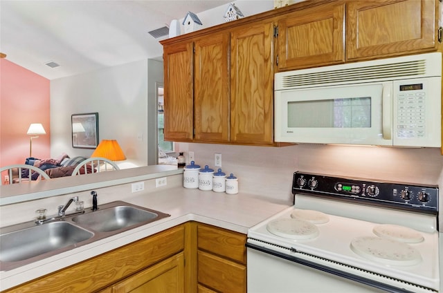 1161 Valleywood Trl, Holly Lake Ranch, TX 75765 - kitchen with white appliances, a sink, light countertops, brown cabinets, and a peninsula