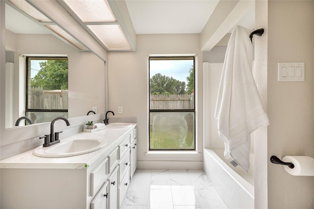 4702 Pamela Dr, Abilene, TX 79606 - bathroom featuring marble look tiles, double vanity, and a tub