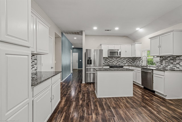 3809 San Lorenzo Dr, Denton, TX 76210 - kitchen featuring stainless steel appliances, tasteful backsplash, dark wood-style floors, dark stone countertops, and white cabinetry