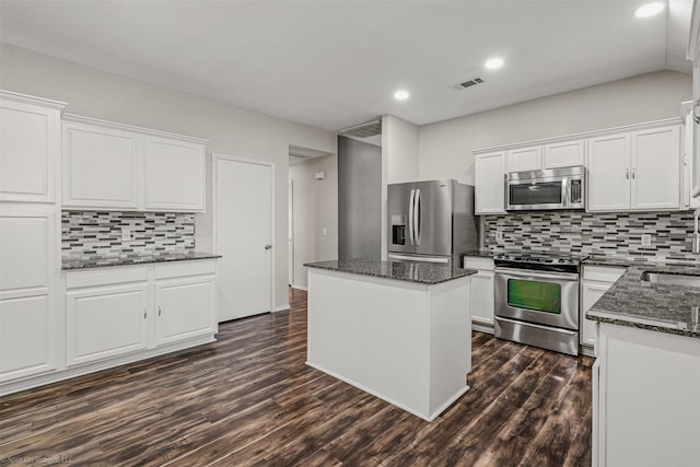 3809 San Lorenzo Dr, Denton, TX 76210 - kitchen with appliances with stainless steel finishes, a center island, backsplash, white cabinets, and dark stone countertops