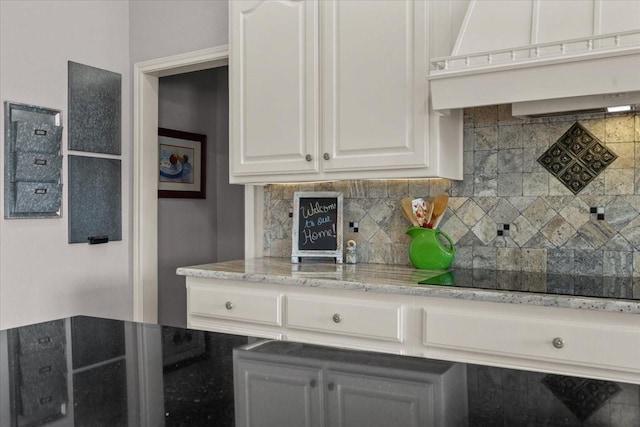 809 Remington Park, Robinson, TX 76706 - kitchen featuring black electric stovetop, custom exhaust hood, tasteful backsplash, white cabinetry, and light stone counters