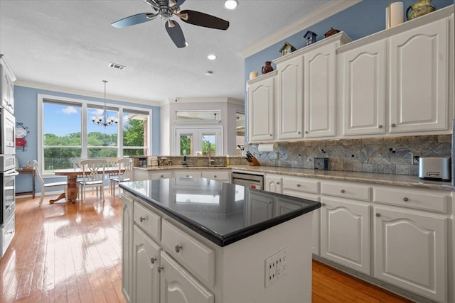 809 Remington Park, Robinson, TX 76706 - kitchen featuring crown molding, ceiling fan, white cabinetry, a center island, and decorative backsplash