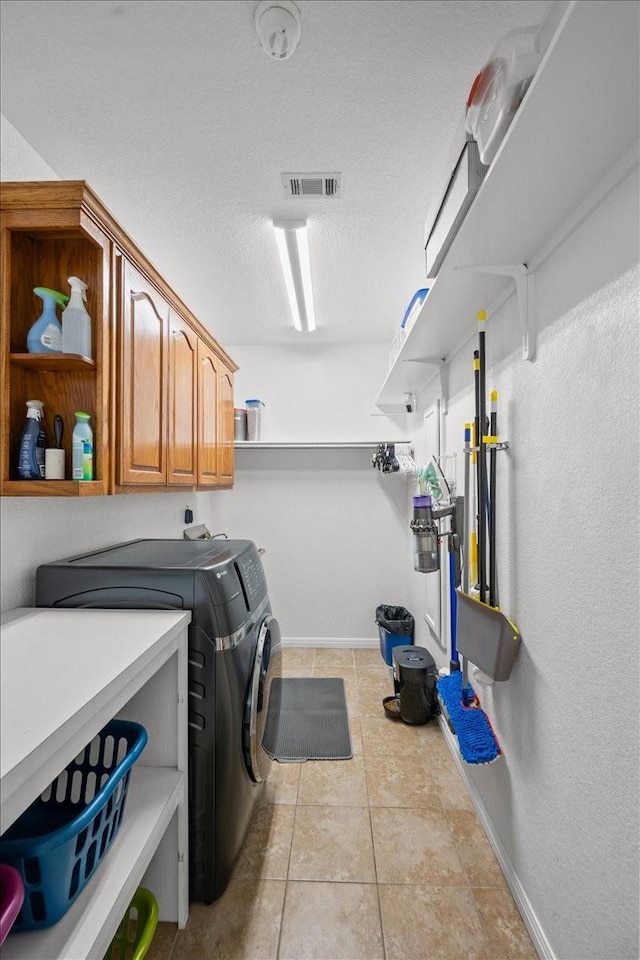 809 Remington Park, Robinson, TX 76706 - washroom with washing machine and dryer, cabinet space, baseboards, tile patterned floors, and a textured ceiling