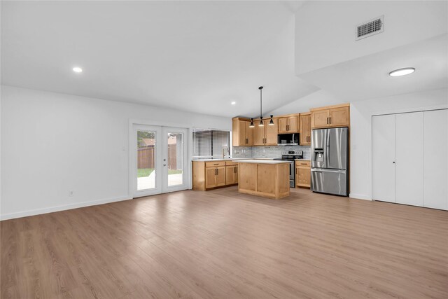808 Warwick Dr, Plano, TX 75023 - kitchen featuring stainless steel appliances, light countertops, vaulted ceiling, open floor plan, and light wood finished floors