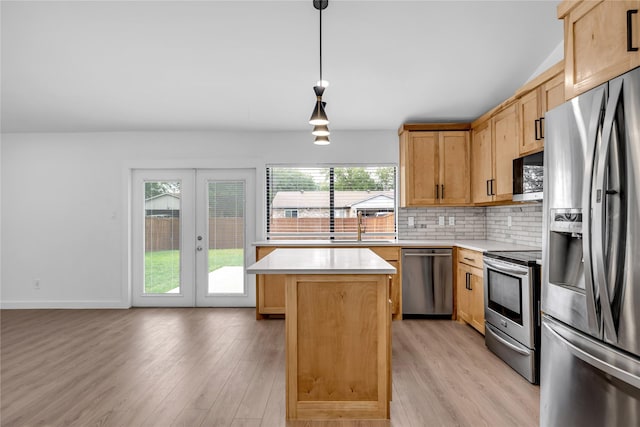 808 Warwick Dr, Plano, TX 75023 - kitchen with stainless steel appliances, light countertops, a center island, a sink, and light wood finished floors