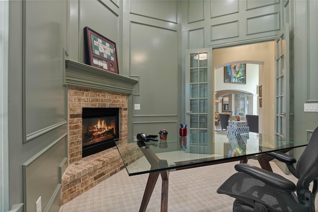 2013 Savannah Dr, Mckinney, TX 75072 - carpeted office with a decorative wall, a brick fireplace, arched walkways, french doors, and a high ceiling