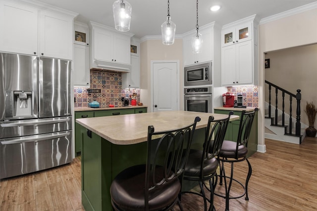 18551 Lazy Ln, Flint, TX 75762 - kitchen with appliances with stainless steel finishes, light countertops, ornamental molding, light wood-style floors, and white cabinets