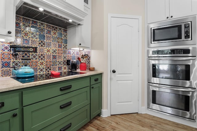 18551 Lazy Ln, Flint, TX 75762 - kitchen with green cabinets, appliances with stainless steel finishes, premium range hood, backsplash, and light countertops