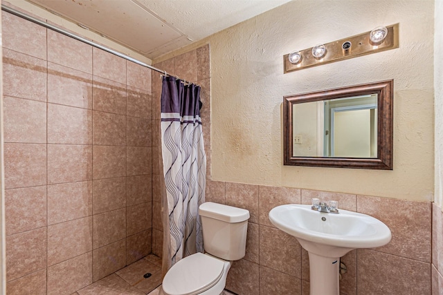 4430 Point Blvd Unit 204, Garland, TX 75043 - full bathroom with toilet, tiled shower, tile walls, and a textured wall