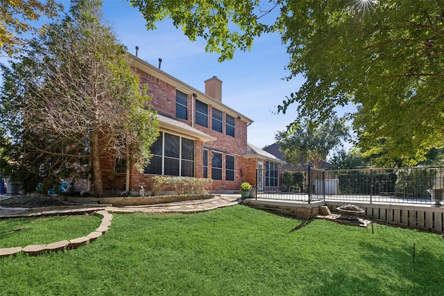 2822 Roundrock, Mckinney, TX 75072 - back of house with brick siding, a chimney, and a fire pit