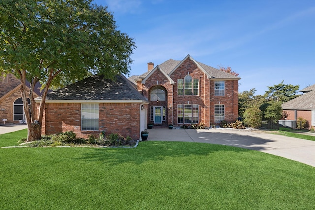 2822 Roundrock, Mckinney, TX 75072 - traditional home with a front yard, a chimney, brick siding, and concrete driveway