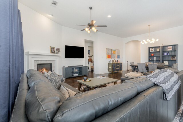 1502 Barley Ct, Forney, TX 75126 - living room with arched walkways, dark wood-type flooring, ceiling fan, a fireplace, and a chandelier