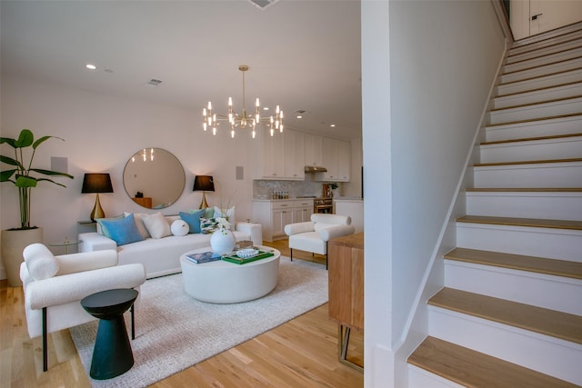 7207 Gaston Ave Unit 1004, Dallas, TX 75206 - living room featuring light wood finished floors, a chandelier, stairway, and recessed lighting