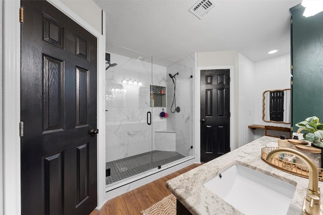 112 Topaz Cir, Hewitt, TX 76643 - full bath featuring wood finished floors, a marble finish shower, vanity, and a textured ceiling