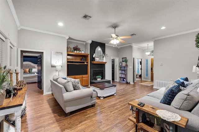 112 Topaz Cir, Hewitt, TX 76643 - living area featuring recessed lighting, a ceiling fan, light wood-type flooring, ornamental molding, and a fireplace