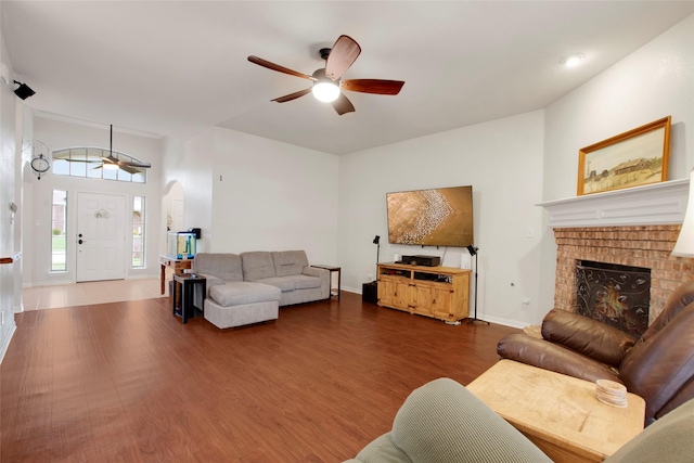 1212 Live Oak St, Royse City, TX 75189 - living room featuring a ceiling fan, dark wood-style flooring, arched walkways, and a fireplace