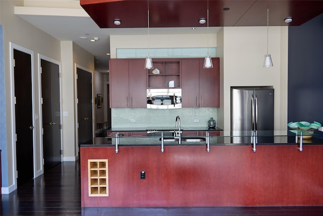 2600 W 7th St Unit 1713, Fort Worth, TX 76107 - kitchen featuring stainless steel appliances, dark countertops, a sink, decorative backsplash, and a breakfast bar