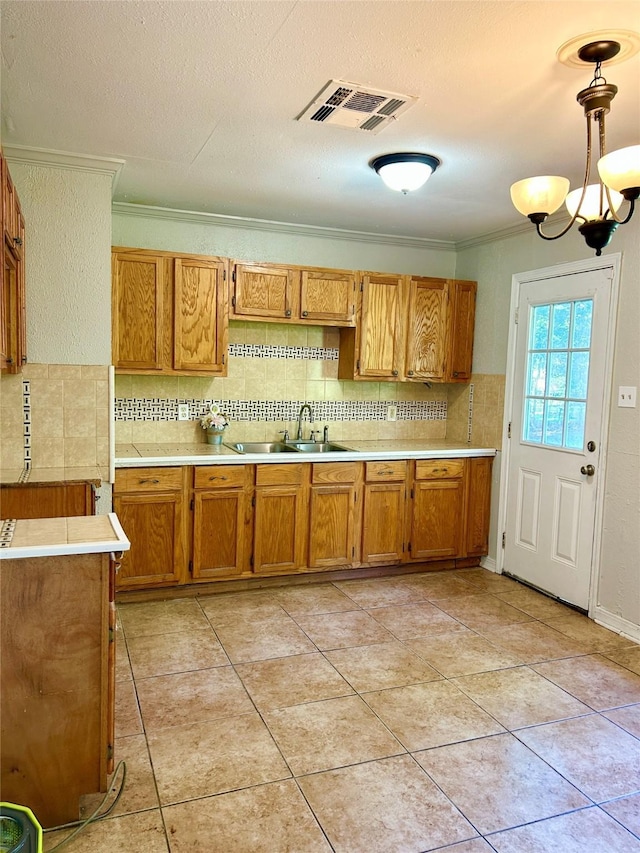 1202 Pin Oak Pl, Shreveport, LA 71107 - kitchen with a sink, light countertops, ornamental molding, decorative backsplash, and brown cabinetry
