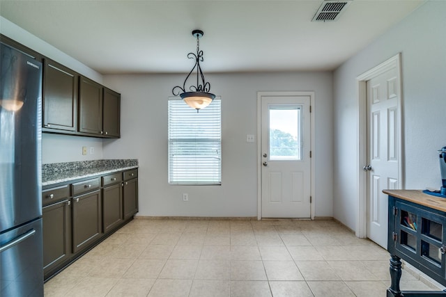 1224 Evergreen St, Royse City, TX 75189 - kitchen featuring freestanding refrigerator, hanging light fixtures, dark brown cabinets, and baseboards