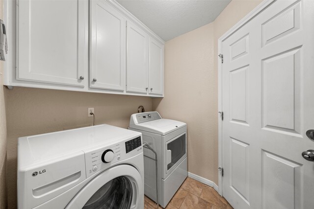 9205 Yellow Stone Rd, Waco, TX 76712 - laundry room featuring washing machine and clothes dryer, cabinet space, baseboards, a textured ceiling, and light stone finish floors