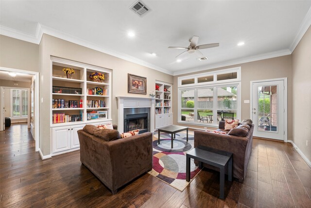 9205 Yellow Stone Rd, Waco, TX 76712 - living room with crown molding, a ceiling fan, dark wood-type flooring, a fireplace, and built in shelves