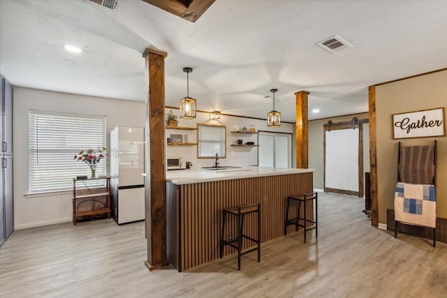 1004 Fairway Ln, Mexia, TX 76667 - kitchen featuring freestanding refrigerator, a barn door, a sink, baseboards, and light countertops