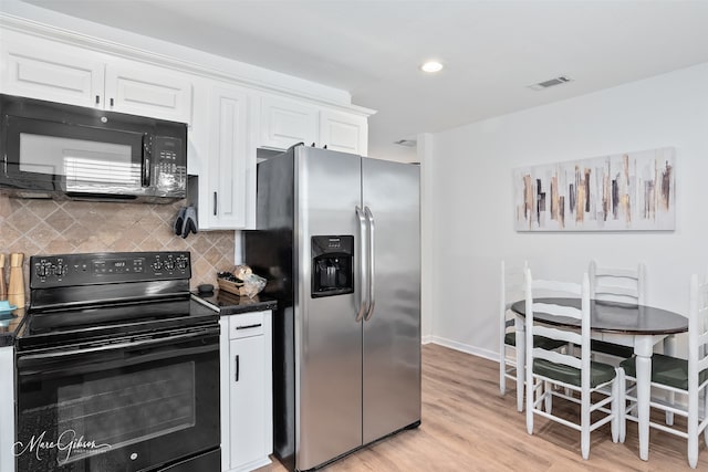 2147 Pine Hill Rd, Shreveport, LA 71107 - kitchen with black appliances, dark countertops, light wood-style floors, white cabinetry, and recessed lighting