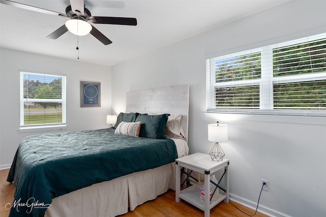 2147 Pine Hill Rd, Shreveport, LA 71107 - bedroom with multiple windows, wood finished floors, baseboards, and a ceiling fan