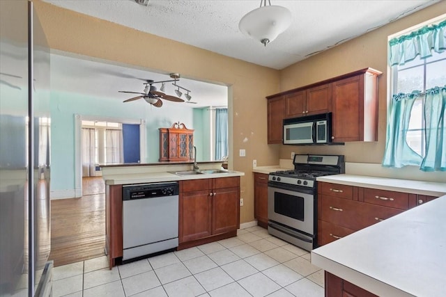 413 Houghton Ave, Marlin, TX 76661 - kitchen with stainless steel appliances, a sink, light countertops, a peninsula, and ceiling fan