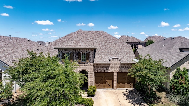 1514 Carnation St, Celina, TX 75078 - french country inspired facade with brick siding, concrete driveway, an attached garage, and roof with shingles